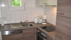 Eine moderne Küche mit Geschirrspüler, Herd und Kaffeemaschine.