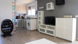 Un appartement moderne doté d’une cuisine, d’un espace de vie avec un téléviseur à écran plat et d’un meuble à vin.