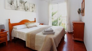 A bedroom with a bed, a nightstand, a dresser, and artwork on the wall. - Valparaiso Apartment Burriana Beach (Nerja)