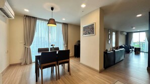 Een moderne woonkamer met een eetgedeelte, grote ramen en uitzicht op de omgeving.
