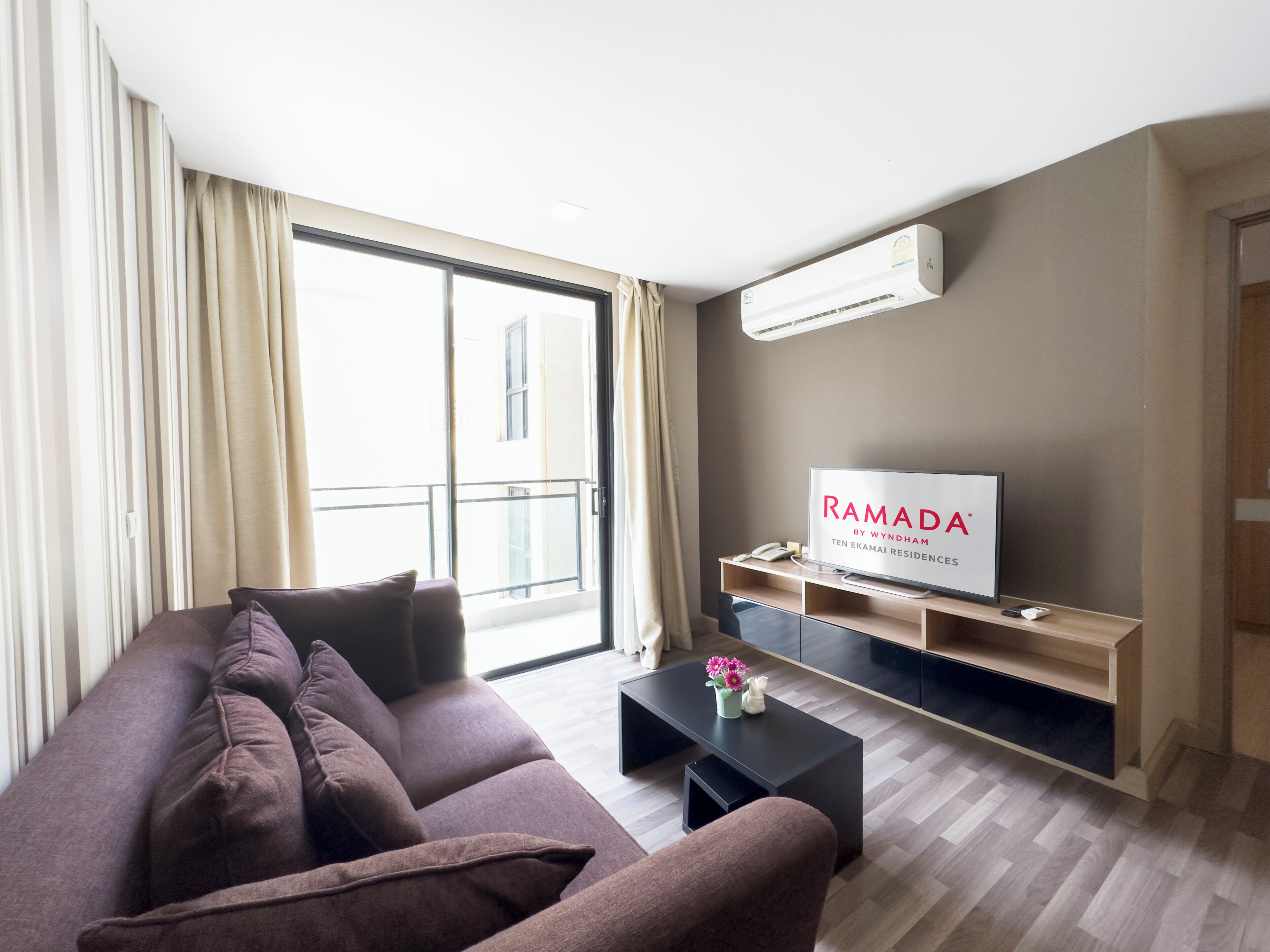 A modern living room with a sofa, a coffee table, and a TV on a wooden stand.