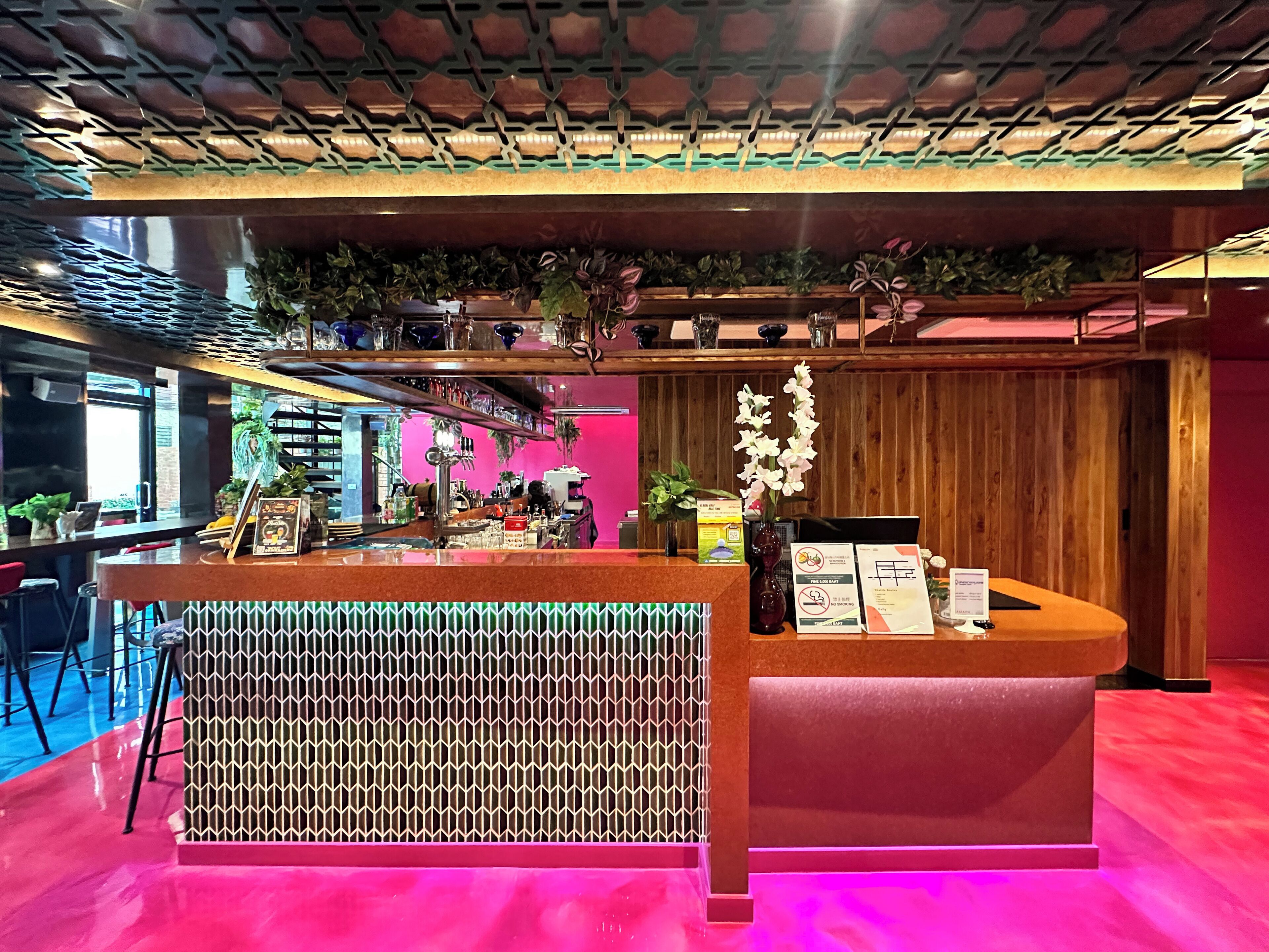 A reception area with a counter, a patterned wall, and a ceiling with a geometric design.