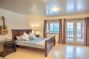 A bedroom with a wooden bed, a nightstand, a guitar, and a window with curtains.