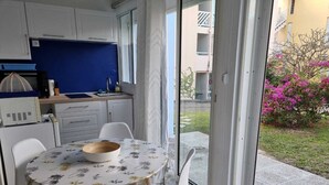 Een kleine keuken met een eethoek, een magnetron en een spoelbak.