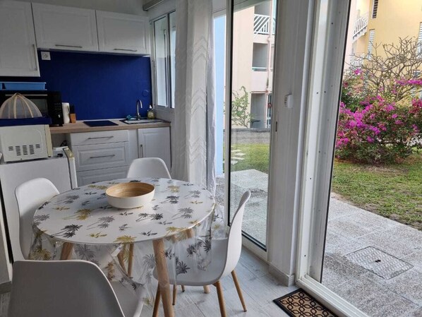 A compact kitchen with a dining area, a microwave, and a sink.