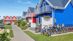 Une rangée de maisons aux couleurs vives, avec une station de location de vélos devant.