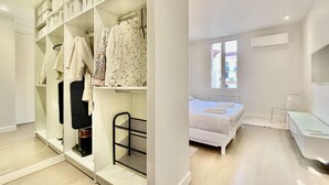 A bedroom with a bed, a window, a desk, and a walk-in closet with shelves and hanging clothes. - Arundel Croisette - 100m Beach Palais - Free Parking AC Fibre (Cannes)