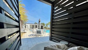 An outdoor patio with a pool, lounge chairs, and a covered seating area. - Gulf Views - Rooftop Deck- Private Poolside Cabana (Santa Rosa Beach)