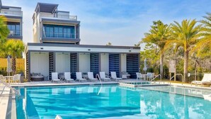 A modern hotel with a swimming pool, sun loungers, and palm trees. - Gulf Views - Rooftop Deck- Private Poolside Cabana (Santa Rosa Beach)