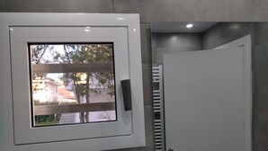 Ein Badezimmer mit Fenster, Handtuchhalter und Tür.