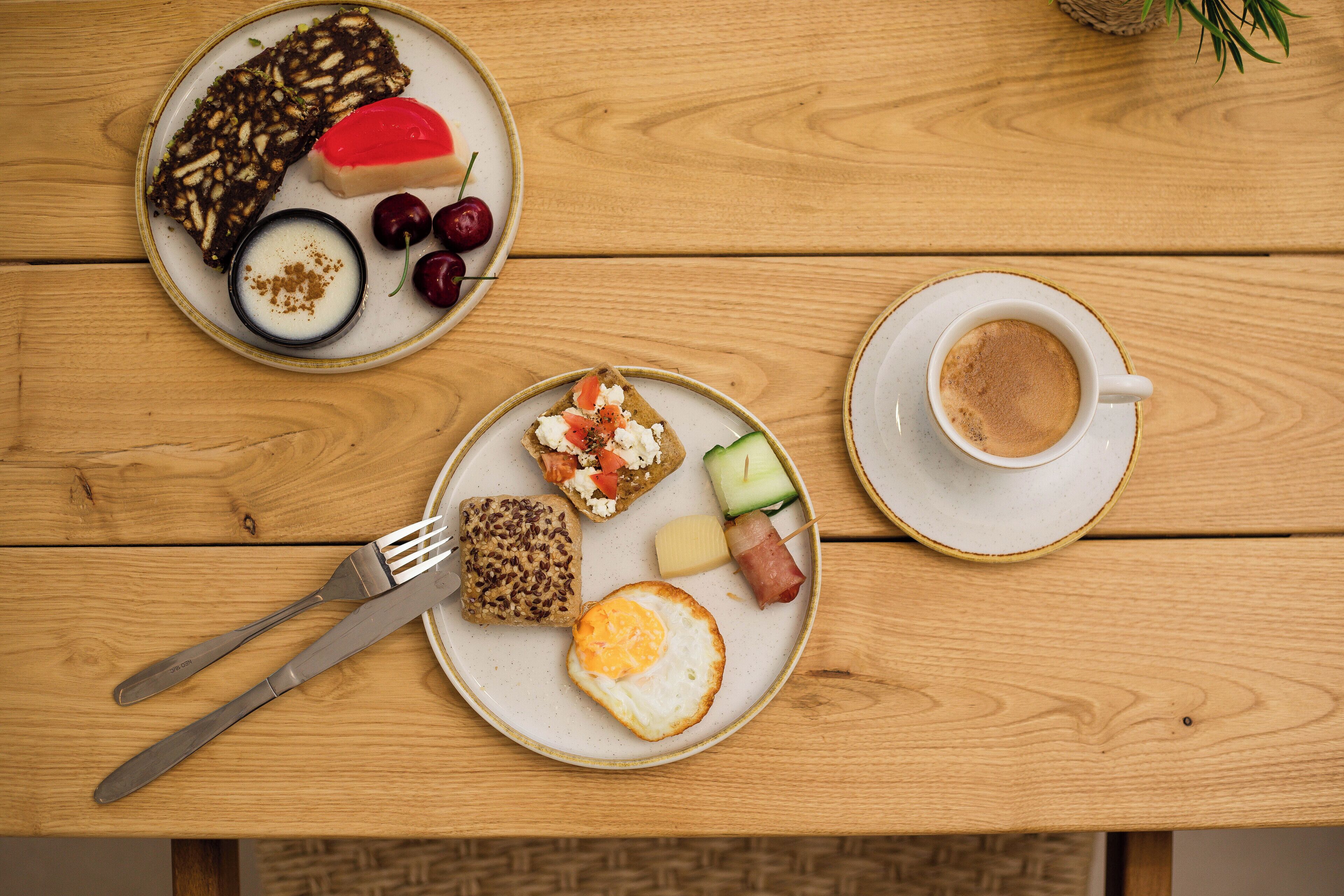 A wooden table with breakfast items including toast, eggs, and fruit.