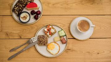 A wooden table with breakfast items including toast, eggs, and fruit.
