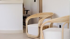 A modern interior with wicker chairs, a white reception desk, and hanging wicker lamps. - Stay Helios - Aparts & Pool Suites (Rhodes)
