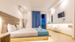 A modern hotel room with a bed, bedside table, TV, and a bathroom visible through a door. - Stay Helios - Aparts & Pool Suites (Rhodes)