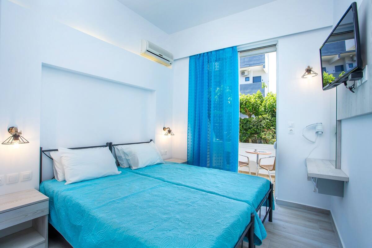 A modern bedroom with a bed, bedside tables, and a view of the outdoors.