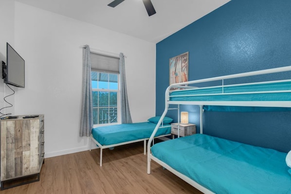 Bunk room with a full bed and two single beds with en suite bathroom