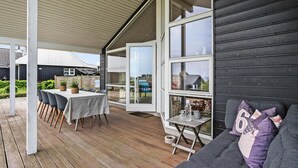 A covered patio with a table and chairs, a small table with decorative items, and a sofa with cushions. - Pet friendly home in Hejls with WiFi (Hejls)