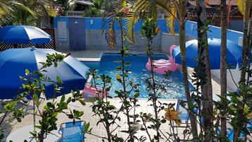 Alberca al aire libre, sombrillas en la alberca y camastros