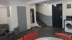 A compact living space with a dining area, a washing machine, and a staircase. - Beautiful 4-6 person gîte in the center of Vallon Pont d'Arc (Vallon-Pont-d'Arc)