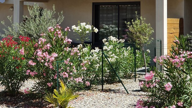 A two-story building with a tiled roof and a covered patio area. - Beautiful 4-6 person gîte in the center of Vallon Pont d'Arc (Vallon-Pont-d'Arc)