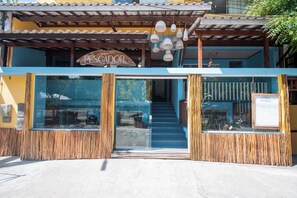 A hotel entrance with a sign reading 'Hotel do Pesador,' a wooden facade, and a staircase leading inside. - Hotel do Pescador (Cairu)