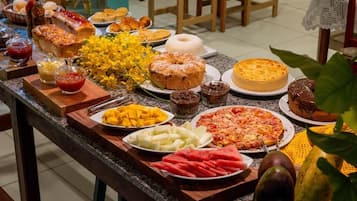 Una mesa de buffet con diferentes alimentos, como pasteles, frutas y postres.