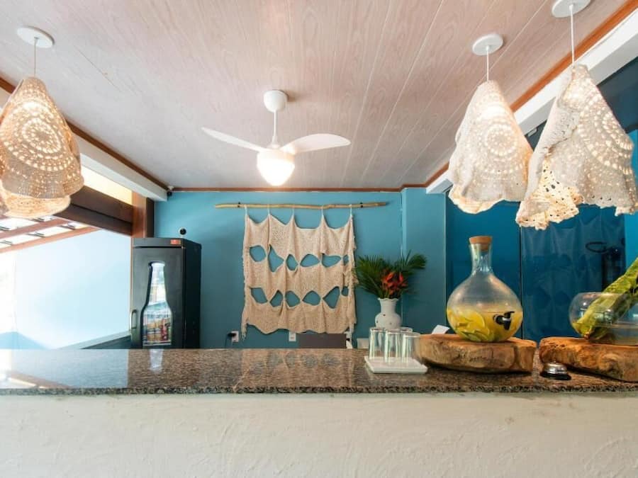 Uma cozinha com ventilador de teto, luminárias pendentes, geladeira e porta-toalhas.