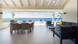 A covered outdoor area with a dining table, chairs, and a sofa. There are ceiling fans and a view of the ocean. - Beautiful villa with breathtaking views and direct access to the sea (Rif St. Marie)