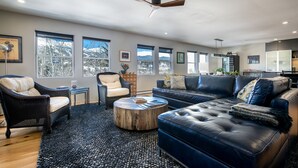 A modern living room with a leather sofa, a round coffee table, and a wicker chair. - Telemark Long Stay Condo: Perfect For 30 Days Or More (Breckenridge)