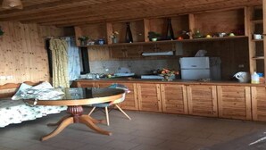 A wooden interior with a dining table, kitchen counter, and cabinets. - Rare and magical panoramic view of Mykonos and the Aegean sea. (Mikonos)