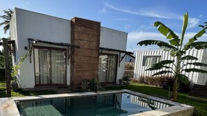 Una casa moderna con piscina, un sendero de piedra y un césped bien cuidado.