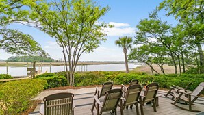 A deck with outdoor seating and a view of a lake. - Community pool, dock, river views! (Kiawah Island)
