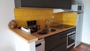 A compact kitchen with a microwave, coffee maker, and a dish rack. - Haven of peace with garden and view - au Bouillat d'Anty (Châtel-Guyon)
