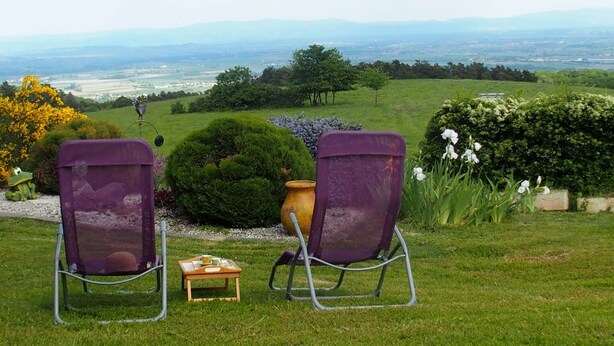 Two purple lawn chairs facing a scenic view of a green landscape with trees and a distant view of mountains. - Haven of peace with garden and view - au Bouillat d'Anty (Châtel-Guyon)