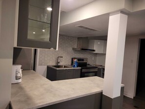 A modern kitchen with a built-in oven, a coffee machine, and a microwave.
