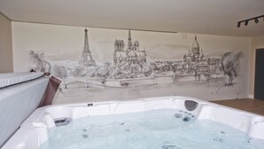 Une pièce avec une grande fresque représentant des monuments célèbres, un jacuzzi blanc et un lit.