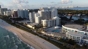 A coastal hotel with multiple high-rise buildings, a beach, and a pool area.