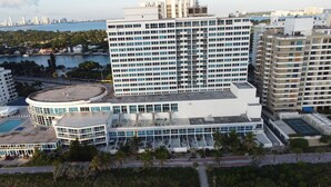A high-rise hotel with multiple floors, a rooftop pool, and a view of the city skyline.