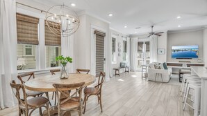 A spacious kitchen with a round wooden table, white chairs, and a large window with blinds. - 3BR Prominence 30A Townhome Near Pool, Sleeps 10 - Spring openings (Watersound)