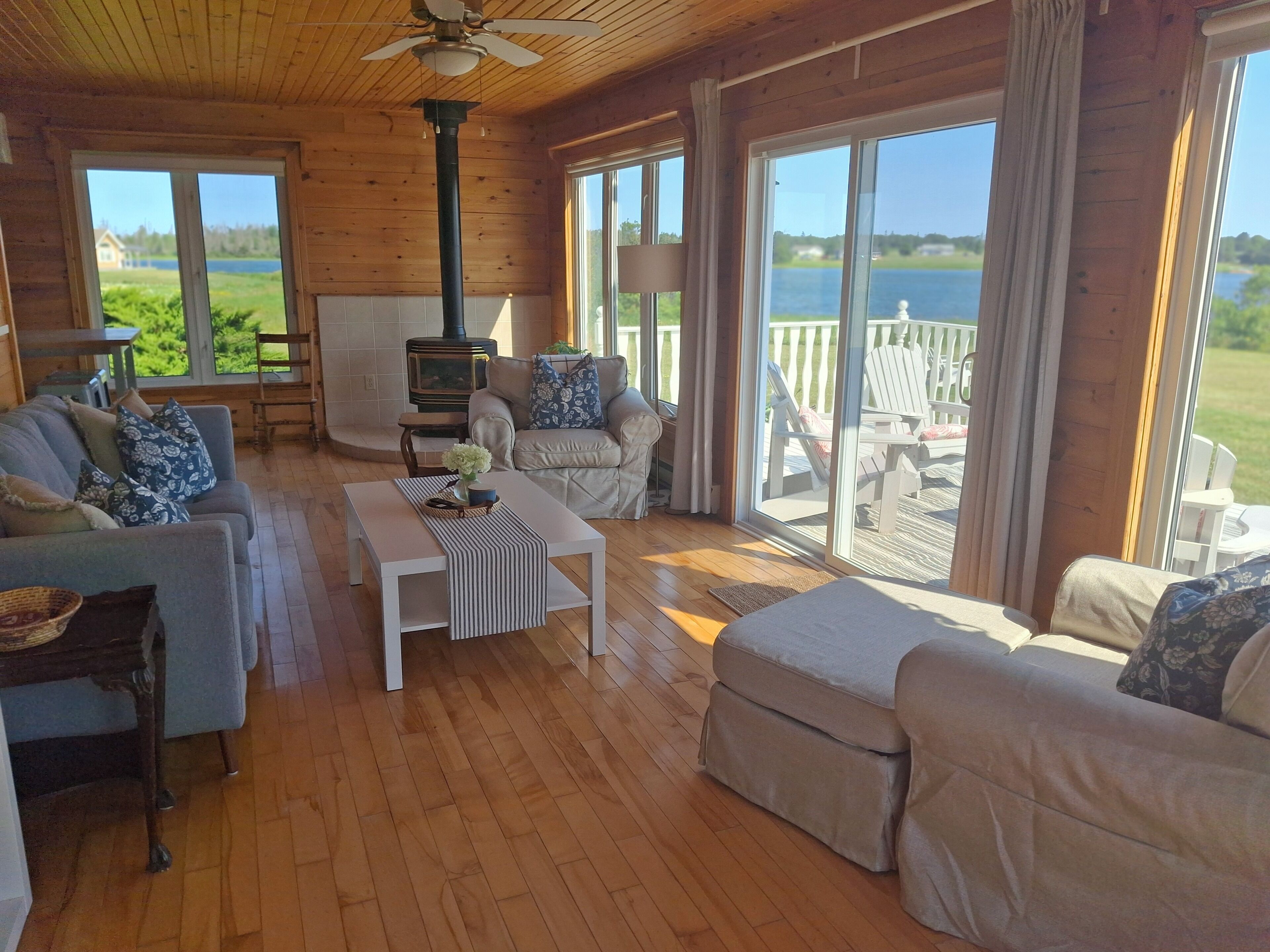Una habitación acogedora con chimenea, un sofá, una mesa y vistas al exterior.