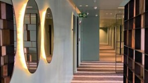 A hallway with bookshelves on both sides, a carpeted floor, and a green exit sign. - Cozy apartment with terrace Cosmopolitan Tower, Nunciatura, San Jose (San José)