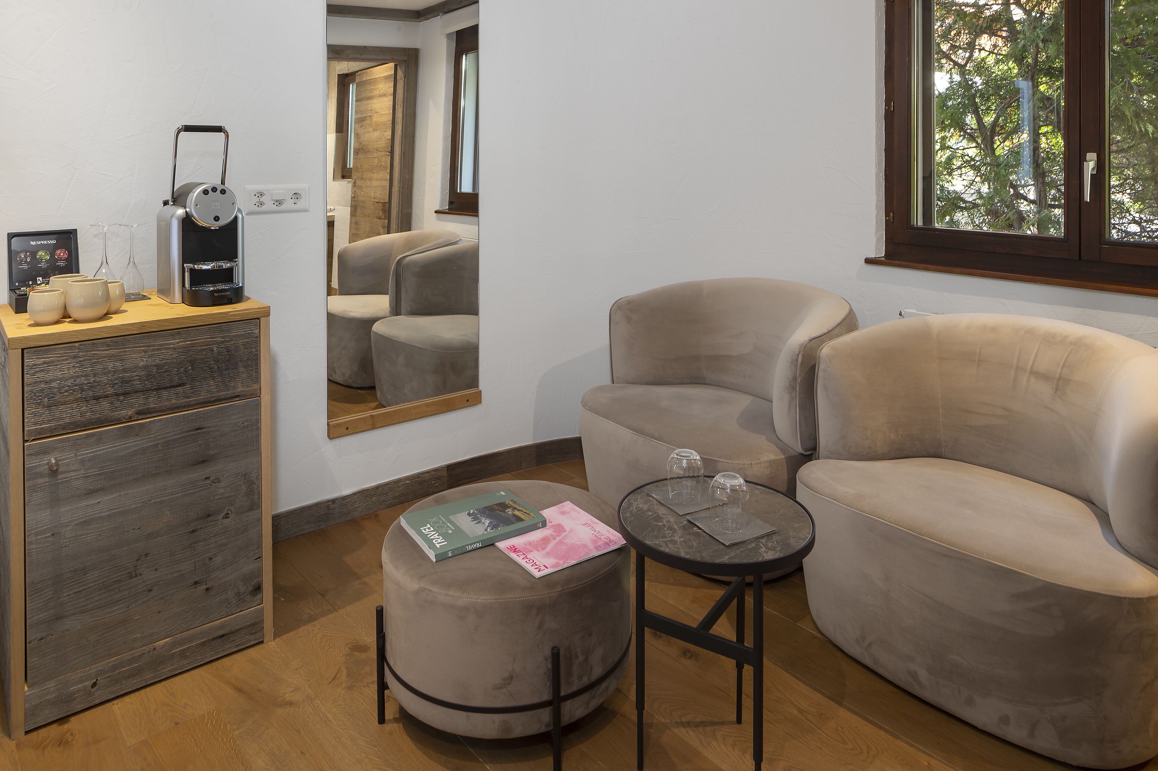 Ein modernes Wohnzimmer mit einer Couch, einem Hocker und einer Kaffeemaschine.