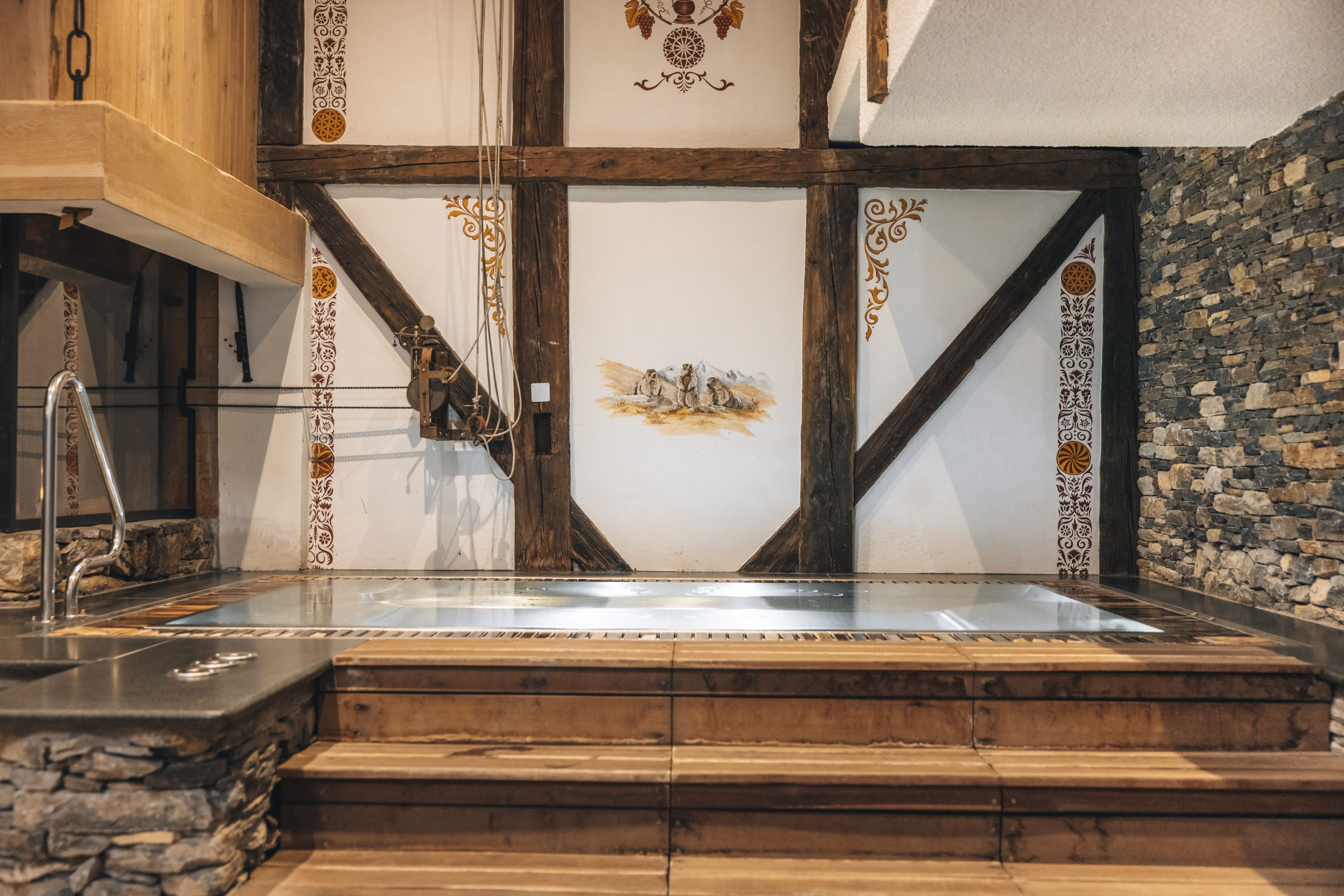 A stone fireplace with a wooden mantel and a metal grate.