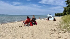 Une plage avec une tente et des gens qui se détendent.