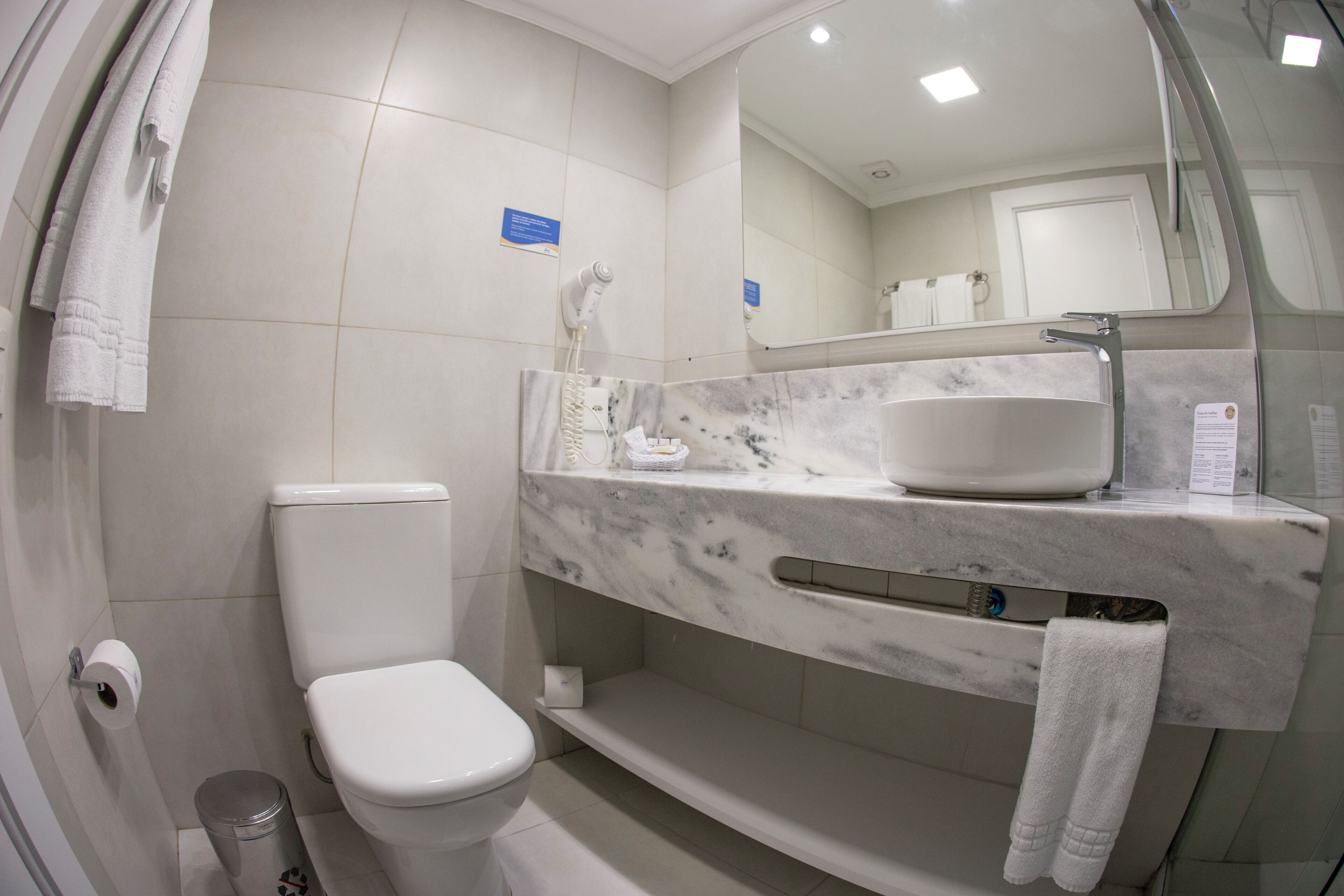 A modern bathroom with a toilet, sink, and shower.