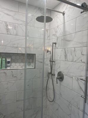 Een bad/douchecombinatie, een haardroger, handdoeken, zeep