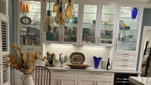 A kitchen with white cabinets, a wooden dining table, and hanging pendant lights. - Executive Home Gated Golf Community close to Masters! (Aiken)