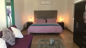 A bedroom with a bed, a nightstand, a dresser, a sofa, and a coffee table. - loft morado (Puerto Peñasco)