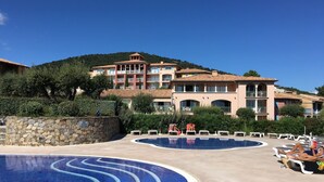 A resort with a large pool area, multiple lounge chairs, and a building with balconies. - 3bedroom flat in Les Issambres Var, superb sea view, pool and air conditioning (Roquebrune-sur-Argens)