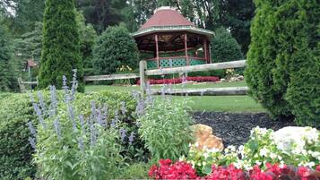 Un kiosque dans un jardin agrémenté de diverses plantes et fleurs.
